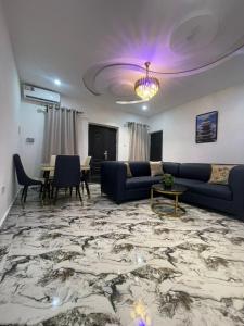 a living room with blue couches and a table at 6c Apartment in Port Harcourt
