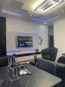 a conference room with a table and chairs and a tv at 6c Apartment in Port Harcourt
