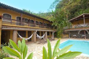 a resort with a swimming pool and a building at Pousada Maanaim 2 in Ubatuba