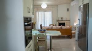 a kitchen and living room with a table and a couch at Η Αυλή της Μαρίας in Áyios Thomás +15 photos