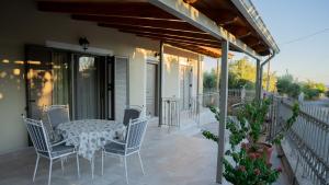 a patio with a table and chairs on a balcony at Η Αυλή της Μαρίας in Áyios Thomás