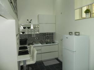 シラクーサにあるIl Vittorialeのキッチン(白いキャビネット、白い冷蔵庫付)