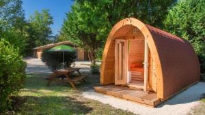 a small wooden tent with a table and an umbrella at Camping le beauvillage Lauzerte in Lauzerte +23 photos