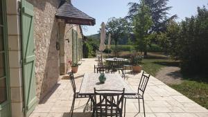 a table and chairs sitting on a patio at Les Bouyssières in Creysse +2 photos