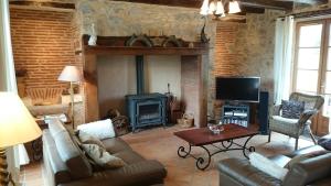 a living room with a couch and a fireplace at Les Bouyssières in Creysse