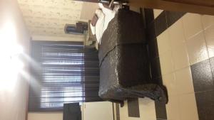 ein Schlafzimmer mit einem Bett mit einer schwarzen Bettdecke in der Unterkunft Family Hotel Kartala in Blagoewgrad
