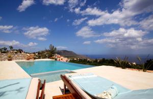 a swimming pool with a view of the ocean at 1891 Home in Epáno Kefalás