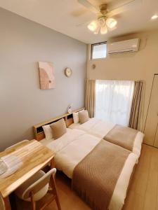 a bedroom with a bed and a table and a window at Le Amo吉塚 in Fukuoka