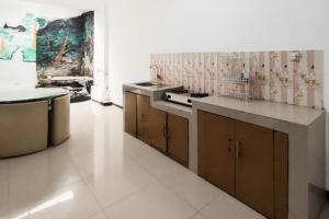a kitchen with a stove and a counter top at Villa Kampoeng City Pacet Mitra RedDoorz in Mojokerto