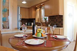 a kitchen with a table with wine glasses and fruit on it at Helen's Sounio Apartments in Sounio