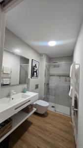 a bathroom with a toilet and a sink and a shower at C&C Suite in San Ciprián