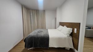 a bedroom with a bed with white sheets and pillows at C&C Suite in San Ciprián