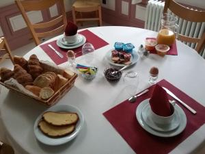 a table with a white table with bread and hats at Château des marronniers in Baizieux +25 photos