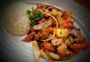 a plate of food with rice and chicken and vegetables at Pension Javorník in Jeřmanice