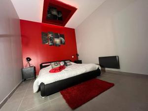 a red bedroom with a bed with a red wall at Le pont des rêves in Pont-sur-Sambre +4 photos