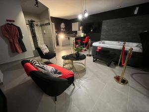 a living room with a tub and a couch and chairs at Le pont des rêves in Pont-sur-Sambre