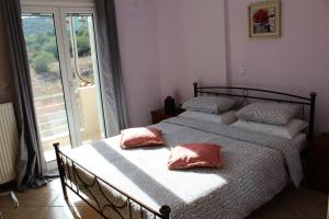 a bedroom with two beds with pink pillows on them at Helen's Sounio Apartments in Sounio