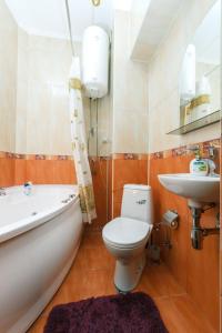a bathroom with a tub and a toilet and a sink at Central Apartments in Kyiv