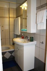 a bathroom with a sink and a bath tub at Helen's Sounio Apartments in Sounio