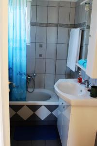 a bathroom with a tub and a sink at Helen's Sounio Apartments in Sounio
