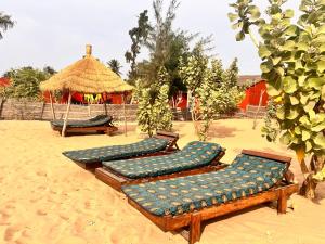 a group of benches sitting on the beach at Case beach in Ngalou Sessène