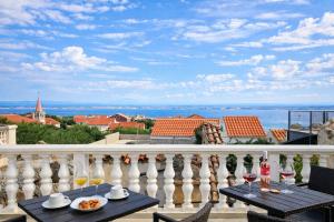 a balcony with a table with food and wine glasses at Casa del Sole - Ugljan Island in Poljana
