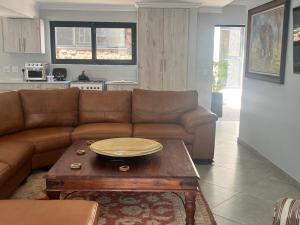 a living room with a brown couch and a coffee table at Comfort Cove in Pretoria