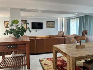 a living room with a couch and a table at Comfort Cove in Pretoria +9 photos