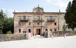 un antiguo edificio de piedra con una pared de piedra en Albergue Monasterio de La Magdalena, en Sarria