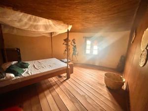 an attic bedroom with a bed and a window at Case beach in Ngalou Sessène
