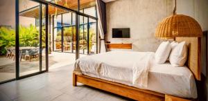 a bedroom with a large bed and a balcony at Pigstone Design Studios Beachfront in Tanah Lot