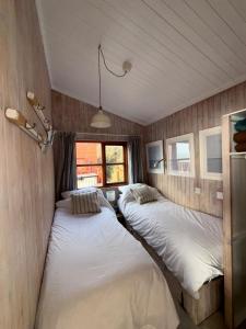 a room with two beds in it with a window at Branscombe Chalet on the Beach in Branscombe +14 photos