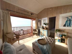 a living room with a view of the ocean at Branscombe Chalet on the Beach in Branscombe