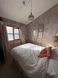 a bedroom with a white bed with a window at Branscombe Chalet on the Beach in Branscombe