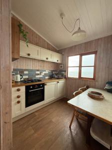 a kitchen with a table and a stove top oven at Branscombe Chalet on the Beach in Branscombe
