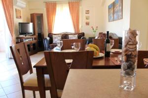 a kitchen and living room with a table and chairs at Helen's Sounio Apartments in Sounio