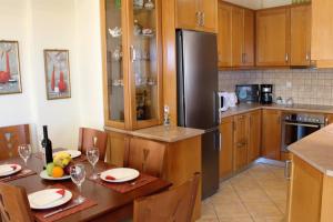 a kitchen with a table and a refrigerator at Helen's Sounio Apartments in Sounio
