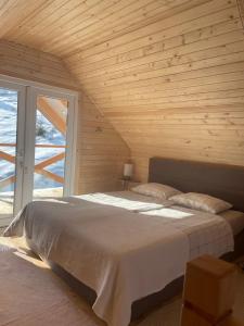 ein Schlafzimmer mit einem großen Bett und einer Holzdecke in der Unterkunft Zwinger in Pilipets