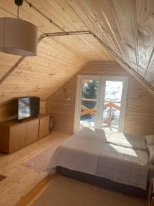 ein Schlafzimmer mit einem großen Bett und einem Fenster in der Unterkunft Zwinger in Pilipets