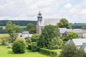 an aerial view of an old church with a tower at B&B - Hotel Le vieux marronnier in Foy-Notre-Dame