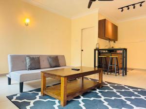 a living room with a couch and a coffee table at Desaru Beach Luxury Suite Pool View C1 in Bandar Penawar