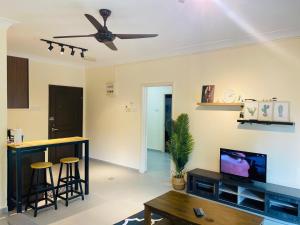 a living room with a ceiling fan and a tv at Desaru Beach Luxury Suite Pool View C1 in Bandar Penawar