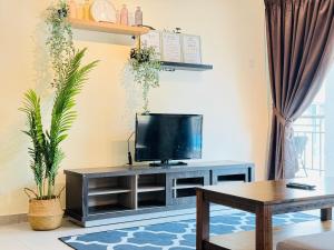 a living room with a tv on a table at Desaru Beach Luxury Suite Pool View C1 in Bandar Penawar