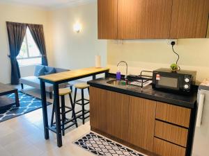 a small kitchen with a counter and a microwave at Desaru Beach Luxury Suite Pool View C1 in Bandar Penawar +24 photos