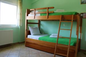 two bunk beds in a room with a ladder at Helen's Sounio Apartments in Sounio