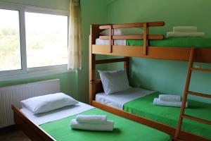 two bunk beds in a room with green walls at Helen's Sounio Apartments in Sounio