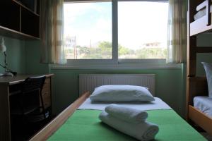 a bedroom with two pillows on a bed with a window at Helen's Sounio Apartments in Sounio
