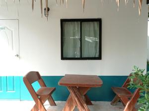 a wooden table and a chair and a window at The Relax Resort in Ko Phangan