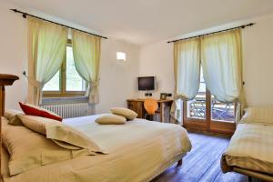 ein Schlafzimmer mit zwei Betten, einem Schreibtisch und einem Fenster in der Unterkunft Ellex Eco Hotel in Gressoney-la-Trinité