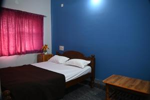 a bedroom with a bed and a blue wall at Ramleela Stay, Gokarna in Ankola +64 photos